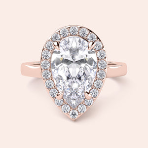 Rose gold teardrop halo engagement ring set featuring pear-shaped diamond, with options in 14K, 18K, or platinum settings.