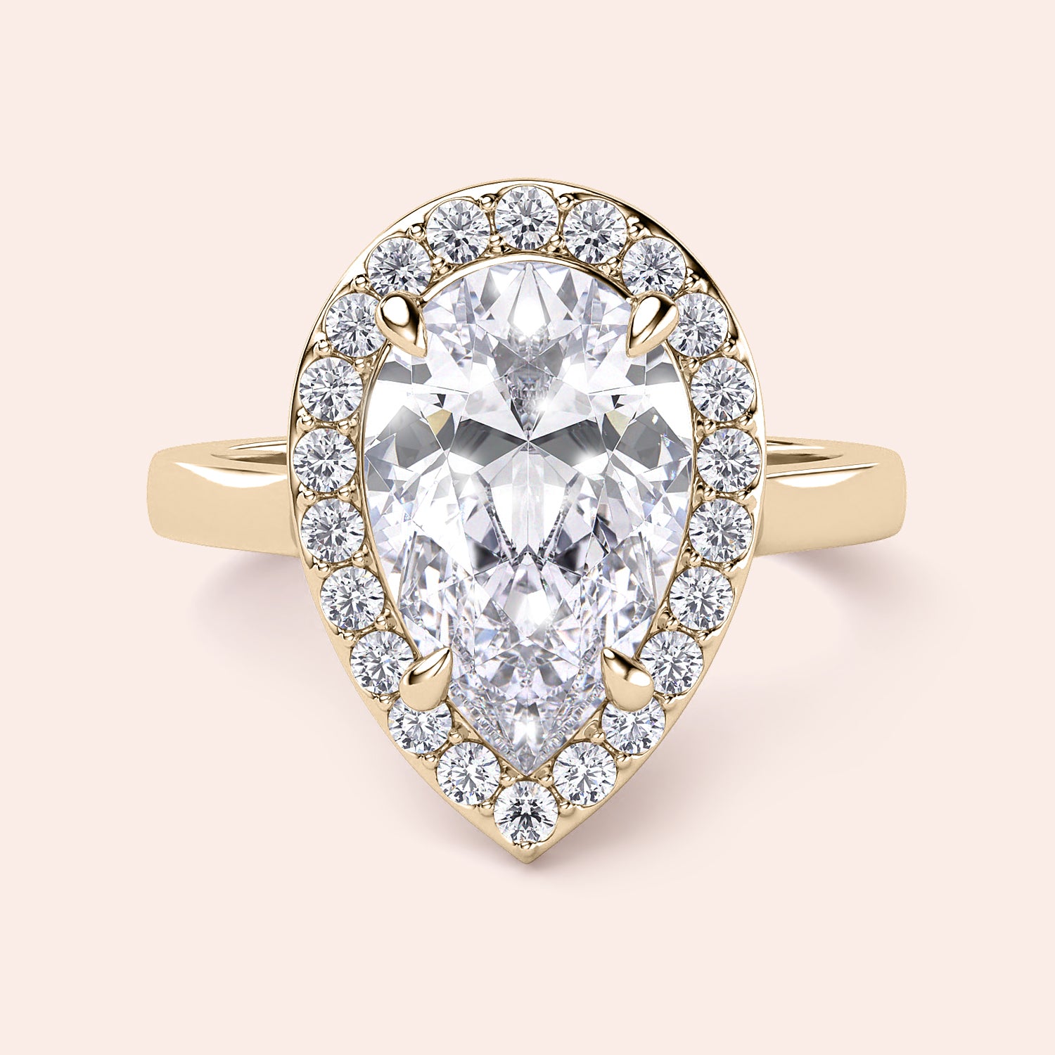 Elegant pear-shaped diamond engagement ring set in 14K or 18K gold, featuring a brilliant halo of smaller diamonds.