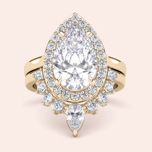 Luxurious pear-shaped diamond engagement ring in 14K gold with halo of smaller diamonds, showcasing intricate design and craftsmanship.