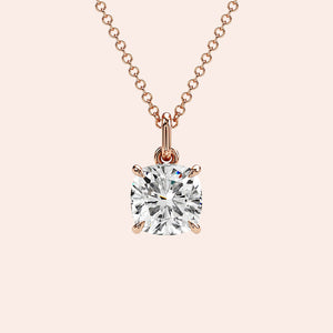 A detailed close-up of a cushion-cut solitaire diamond pendant set in a four-prong rose gold basket. The refined craftsmanship highlights the brilliance of the diamond, making it a must-have piece for any fine jewelry collection.