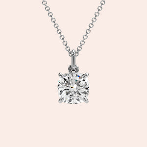 A detailed close-up of a cushion-cut solitaire diamond pendant set in a four-prong white gold basket. The refined craftsmanship highlights the brilliance of the diamond, making it a must-have piece for any fine jewelry collection.