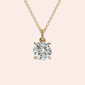 A front-facing view of a cushion-cut solitaire diamond pendant set in a delicate four-prong yellow gold setting. This classic and elegant design enhances the diamond’s brilliance, making it an iconic jewelry staple for any occasion.